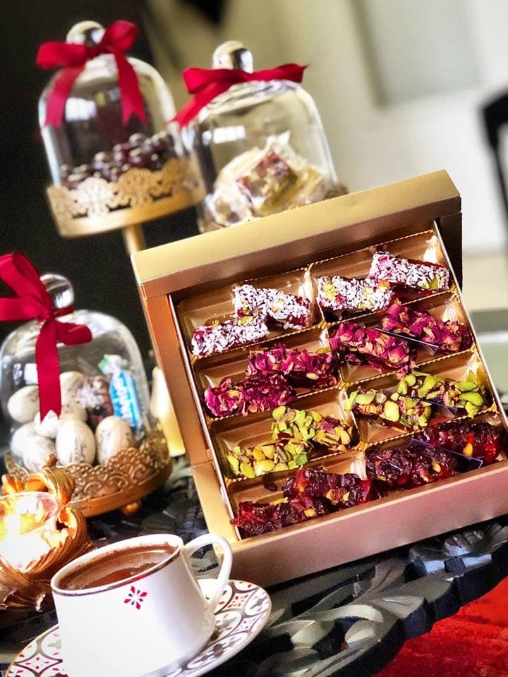 Coffret doré de loukoums aux pétales de rose, à la pistache et à la noix de coco, servi avec un café