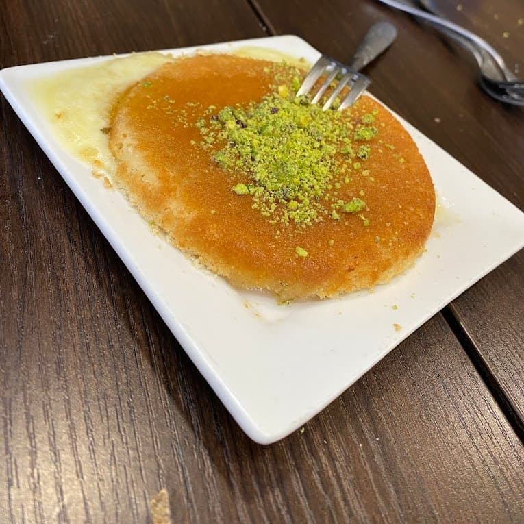 Knafeh servie à l’assiette, parsemée de pistache